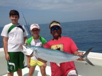 One boy one girl and fishing mate holding a cero mackerel