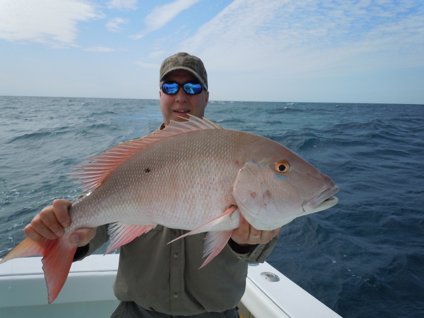 customer hold a mutton snapper on the southpaw fishing charter boat
