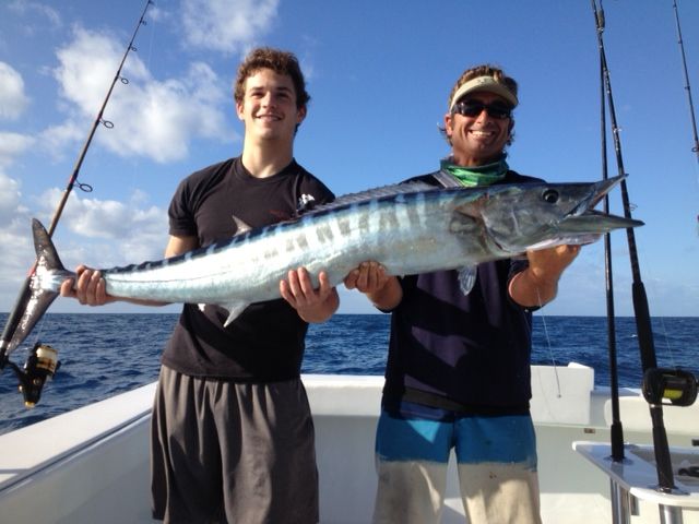 crew and man holding a wahoo on the southpaw deck