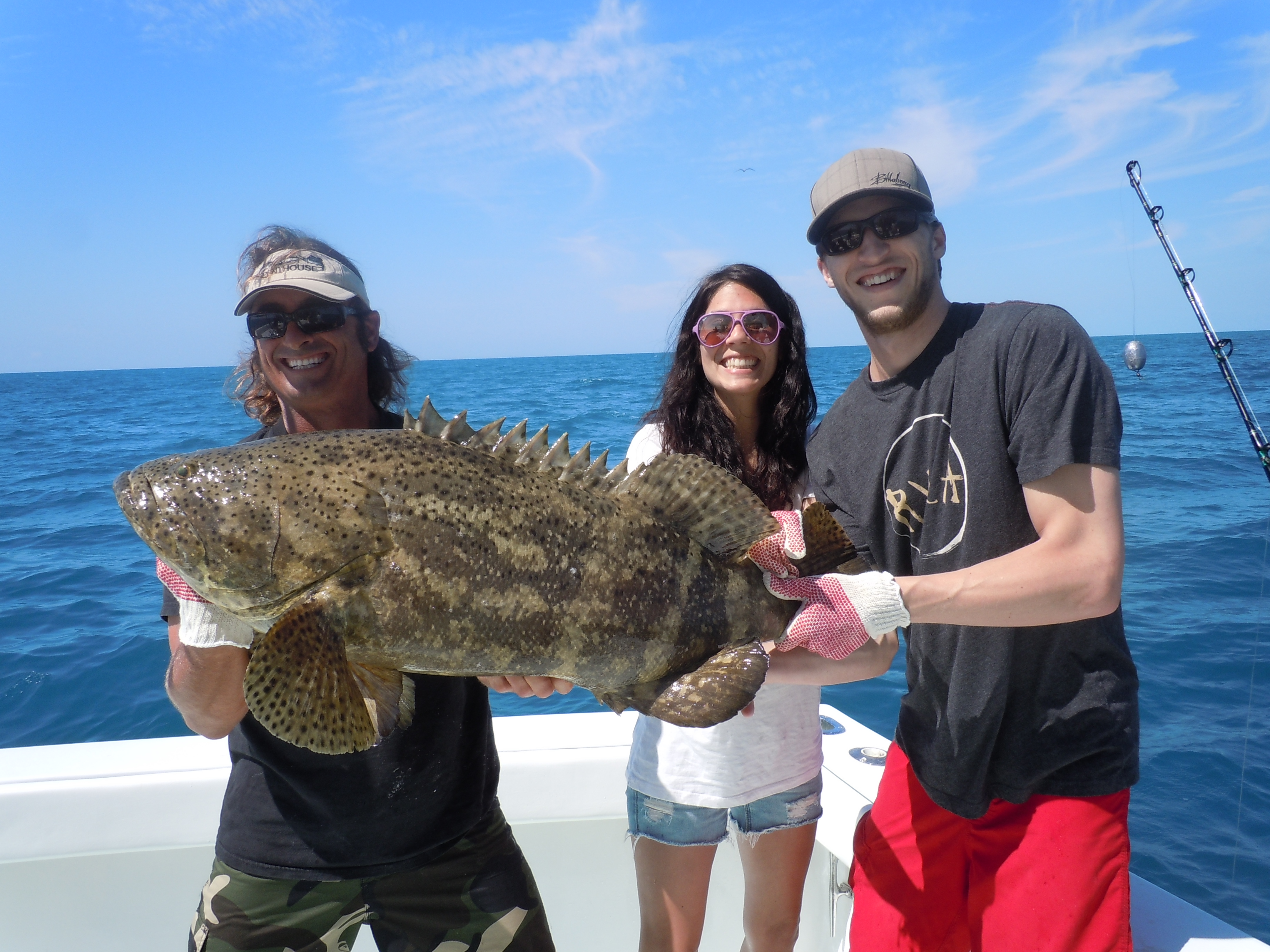 fishing charter holding a goliath grouper