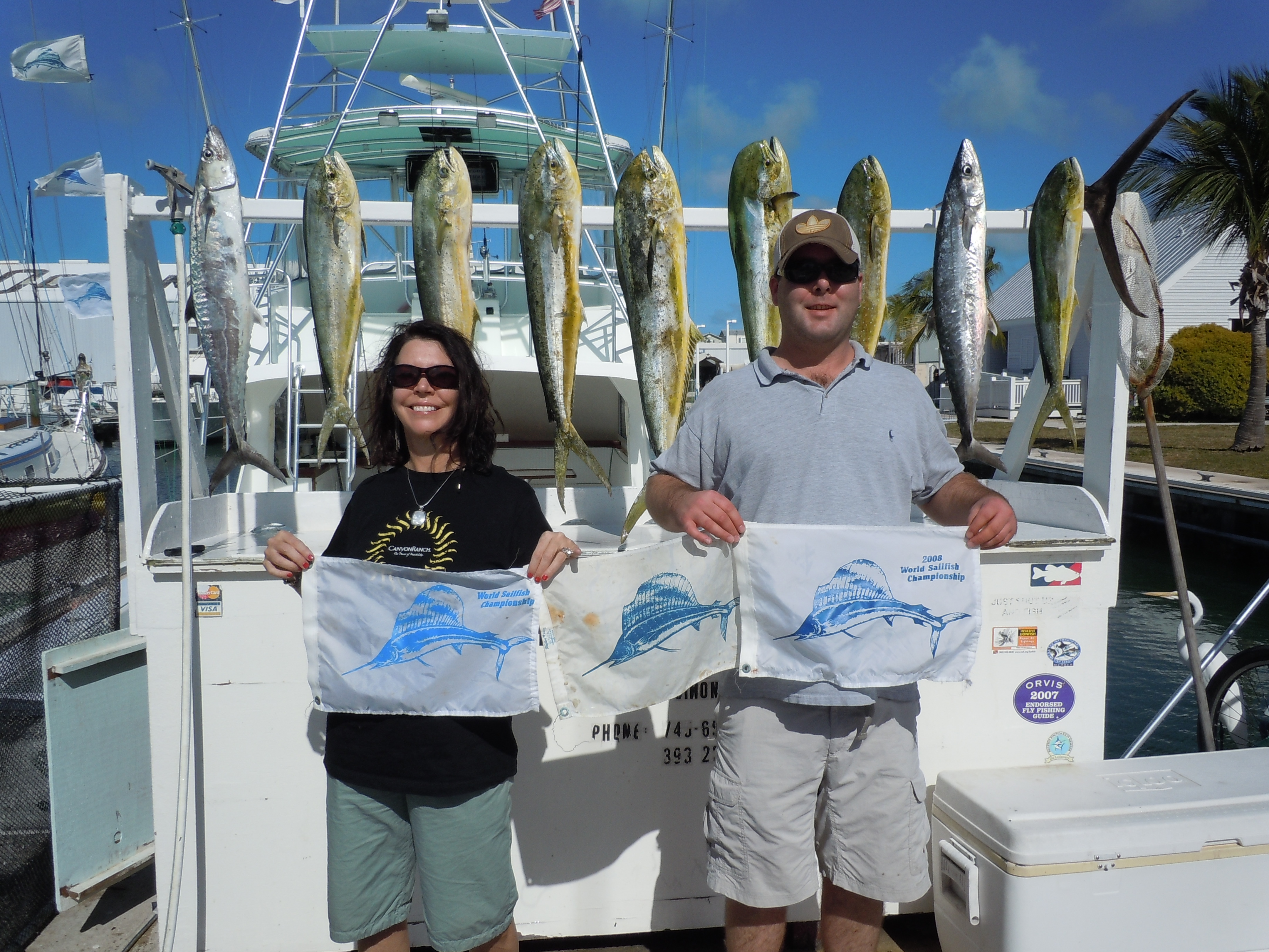 Couple with sailfish 3 catch and release flags and dolphin