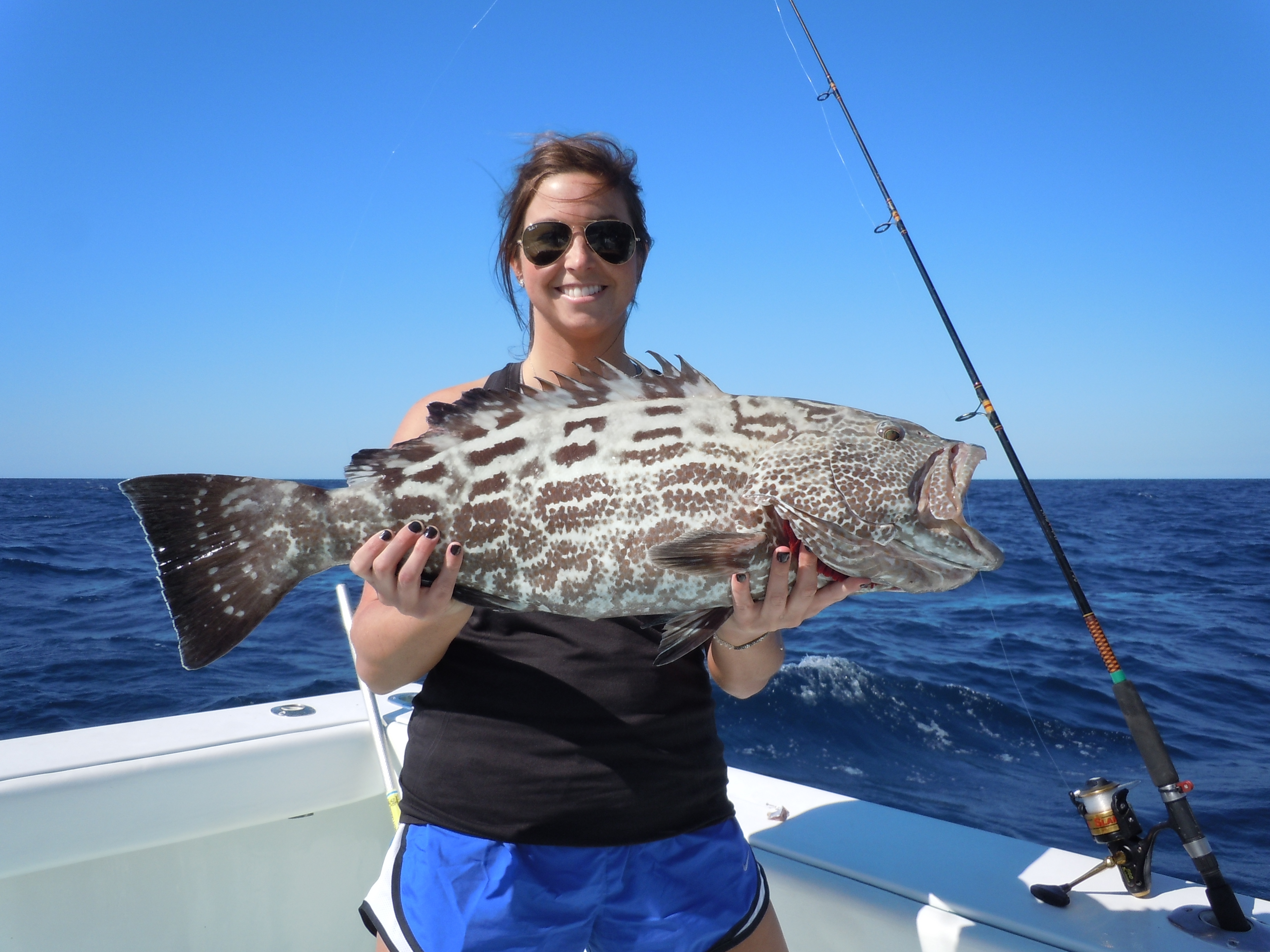 woman holding black grouper