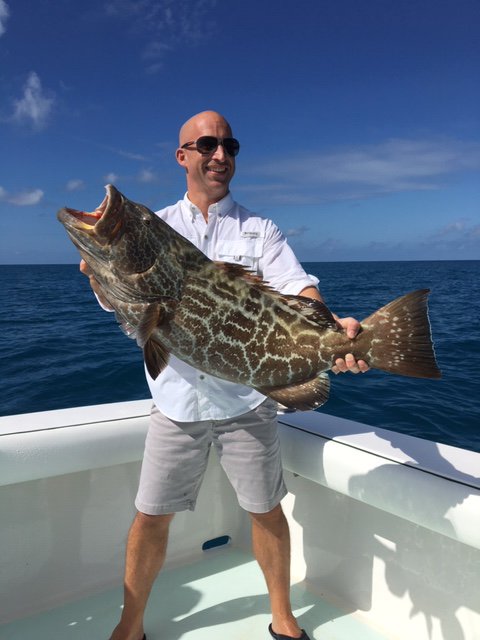 Happy client with a black grouper