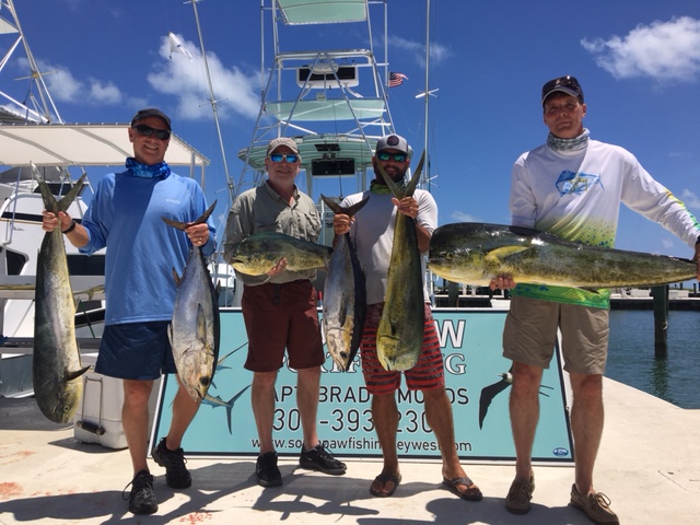 charter posing with their catch on the dock