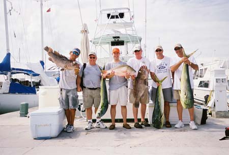 Group charter holding their catch at the dock.