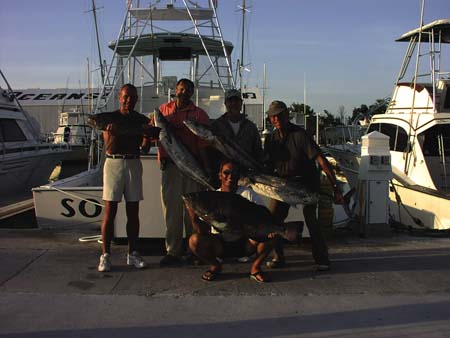 Group holding their fishing charter catch