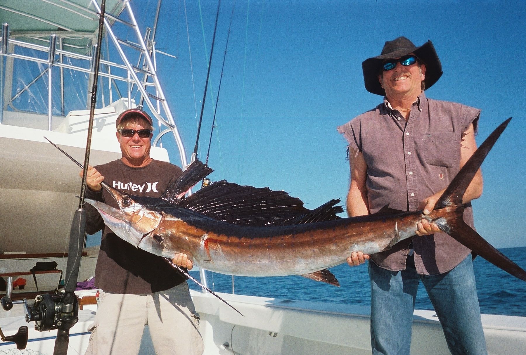 2 men holding a sailfish